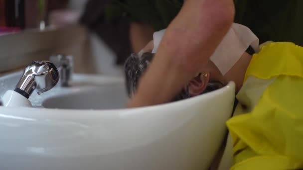 男性の美容師洗濯女性の髪 — ストック動画