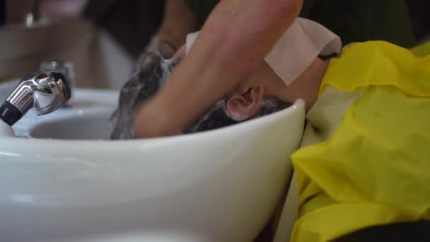 男性の美容師洗濯女性の髪 — ストック動画