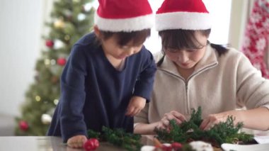 Parents and children making Christmas wreaths