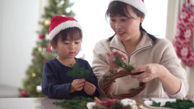 Parents and children making Christmas wreaths