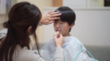 mother cutting child's hair