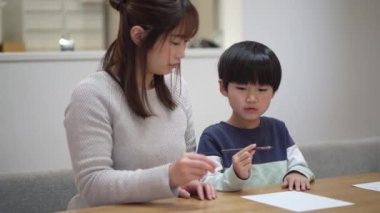 Parents and children practicing how to hold a pencil