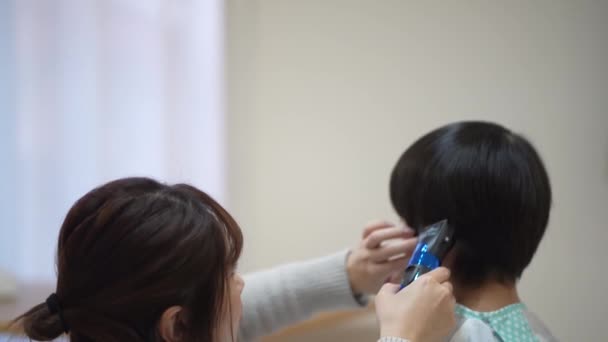 妈妈用剪子剪孩子的头发 — 图库视频影像