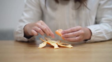 A woman who eats the white streaks of a mandarin orange