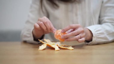 A woman who eats the white streaks of a mandarin orange