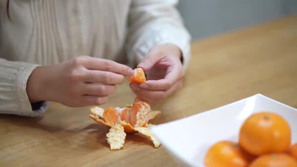 Μια Γυναίκα Που Τρώει Τις Άσπρες Ραβδώσεις Ενός Πορτοκαλιού Μανδαρίνου — Αρχείο Βίντεο