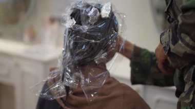 Male beautician applying makeup to a woman