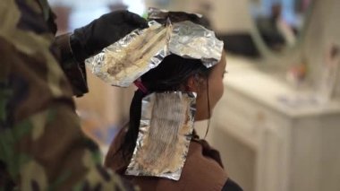 Erkek kuaför kadının saçına uyuşturucu sürüyor.