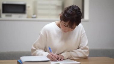 A woman studying while watching a video