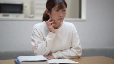 A woman studying while watching a video