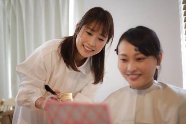 Image of a woman putting on makeup