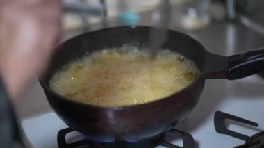 Woman frying potatoes at home