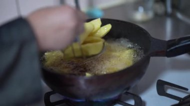 Woman frying potatoes at home