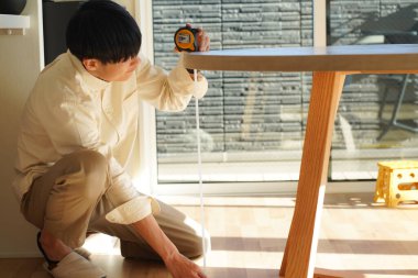 man measuring table height
