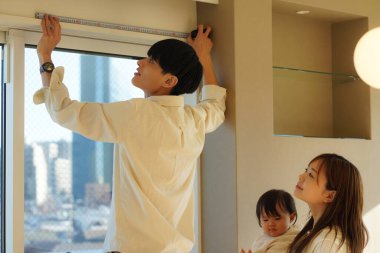 Parents and children measuring the room with a measure