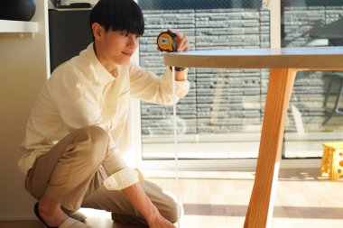man measuring table height