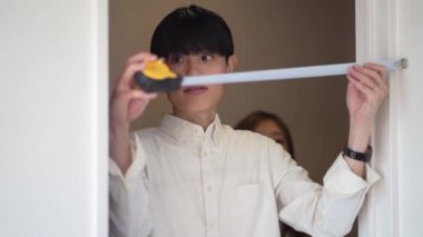 Parents and children measuring the room with a measure
