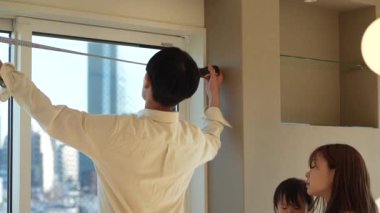 Parents and children measuring the room with a measure