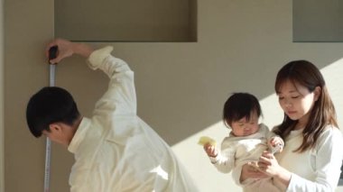 Parents and children measuring the room with a measure