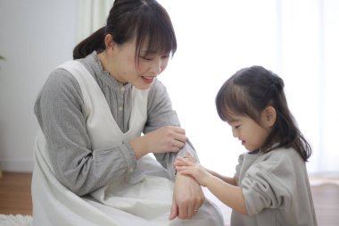 Parent and child applying moisturizing cream