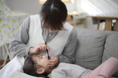 mother brushing child's teeth