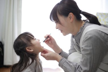 mother brushing child's teeth