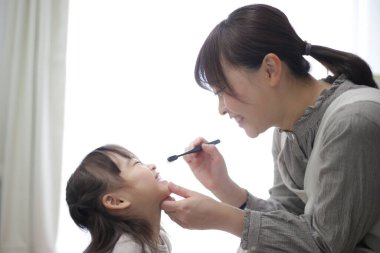 mother brushing child's teeth