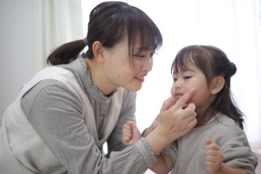 Parent and child applying moisturizing cream