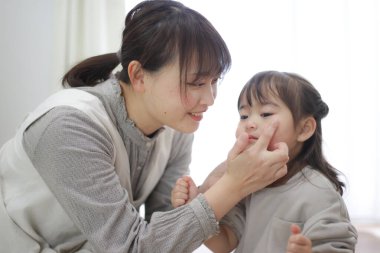 Parent and child applying moisturizing cream