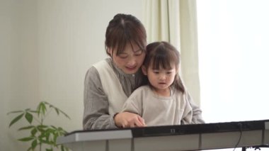 Parents and children practicing playing the piano