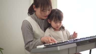 Parents and children practicing playing the piano