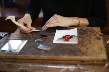 A woman making a stained glass work