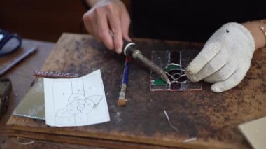 A woman making a stained glass work