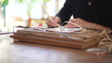 A woman making a stained glass mirror