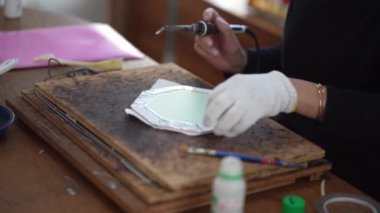 A woman making a stained glass mirror