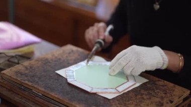 A woman making a stained glass work