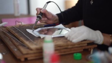 A woman making a stained glass mirror