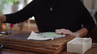 A woman making a stained glass work
