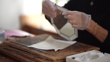 A woman making a stained glass mirror