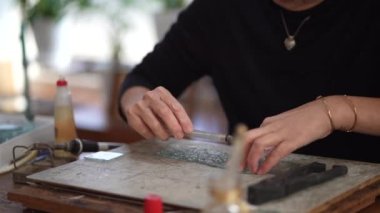 A woman making a stained glass work