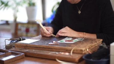 A woman making a stained glass mirror