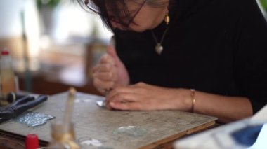 A woman making a stained glass work