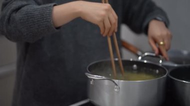 Image of a woman boiling spaghetti