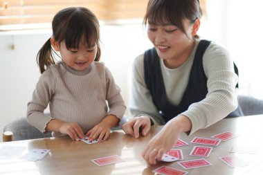 Ebeveynler ve çocuklar kart oynuyorlar