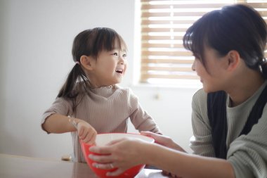 Ebeveyn ve çocuk elle puding yapıyor.
