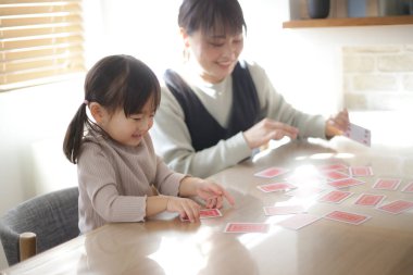 Ebeveynler ve çocuklar kart oynuyorlar