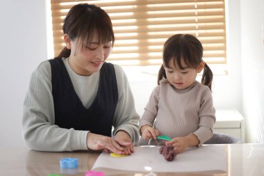 Ebeveyn ve çocuk kille oynuyor