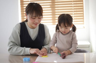 Ebeveyn ve çocuk kille oynuyor