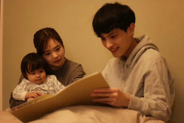 Stock image Parent and child reading a picture book