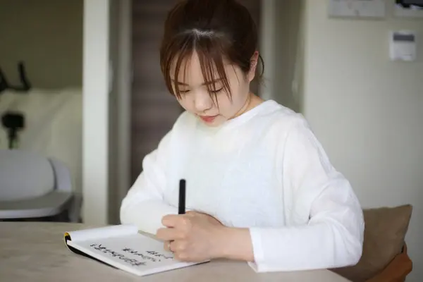 A woman writing with a brush pen